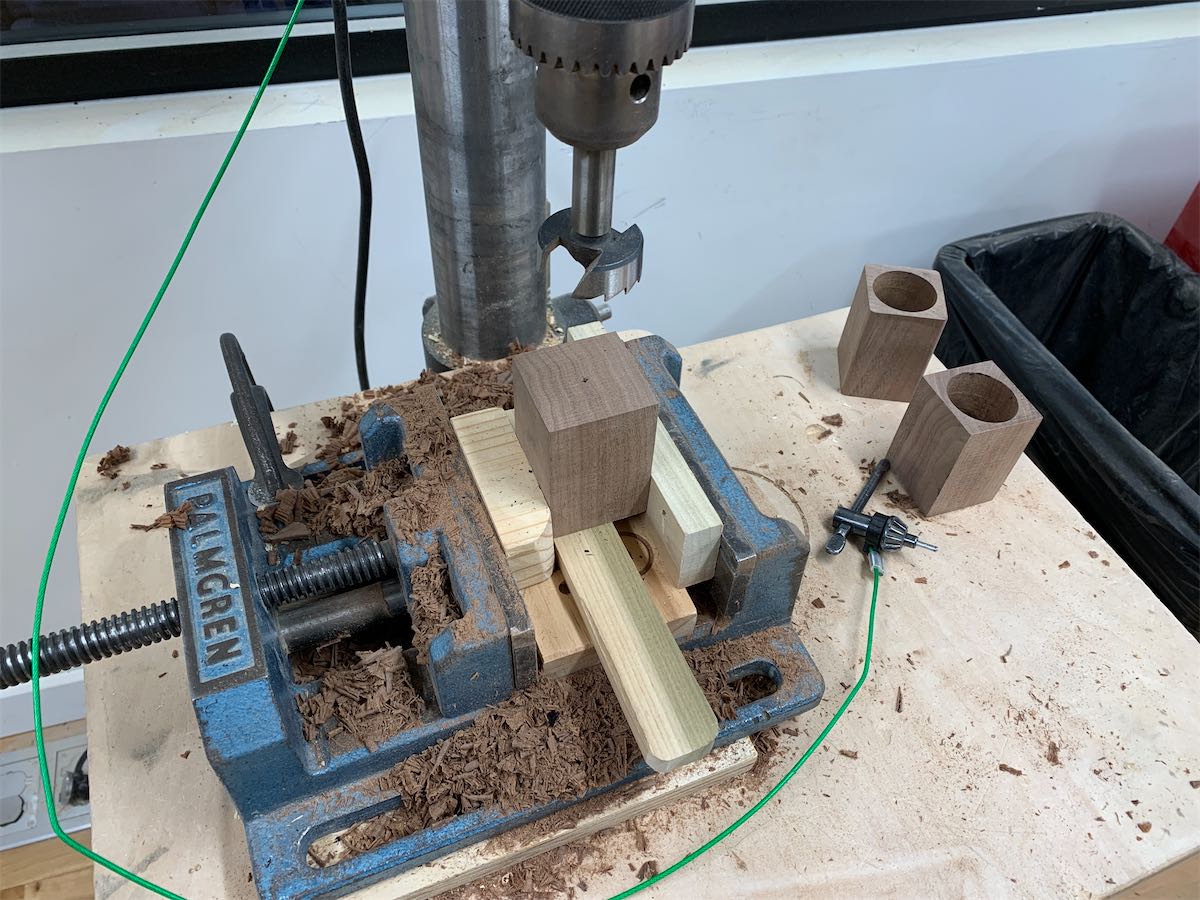 clamped wood under a drill press